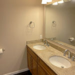 a bathroom with a double sink and a large mirror