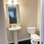 a white toilet sitting next to a white bathroom pedestal sink