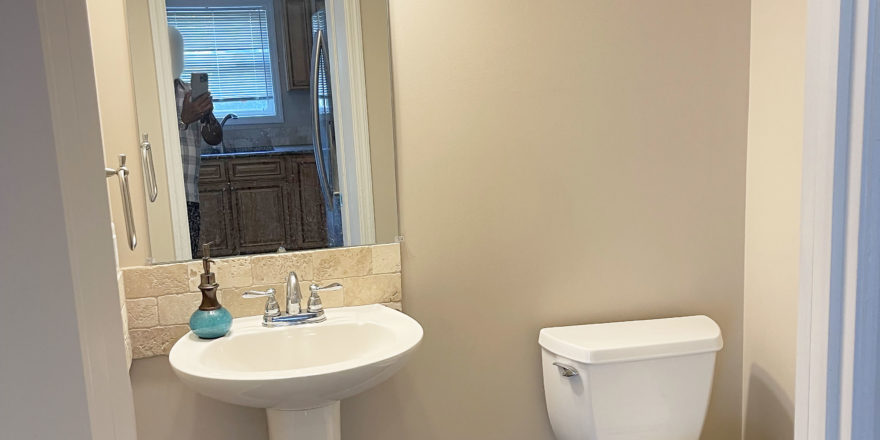 a white toilet sitting next to a white bathroom pedestal sink