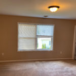an empty room with a closet and large window