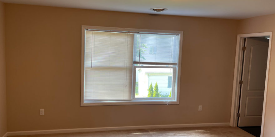 an empty room with a closet and large window
