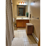 a bathroom with a toilet, sink and shower