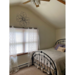 a bedroom with a ceiling fan and a bed