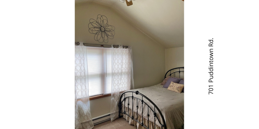 a bedroom with a ceiling fan and a bed