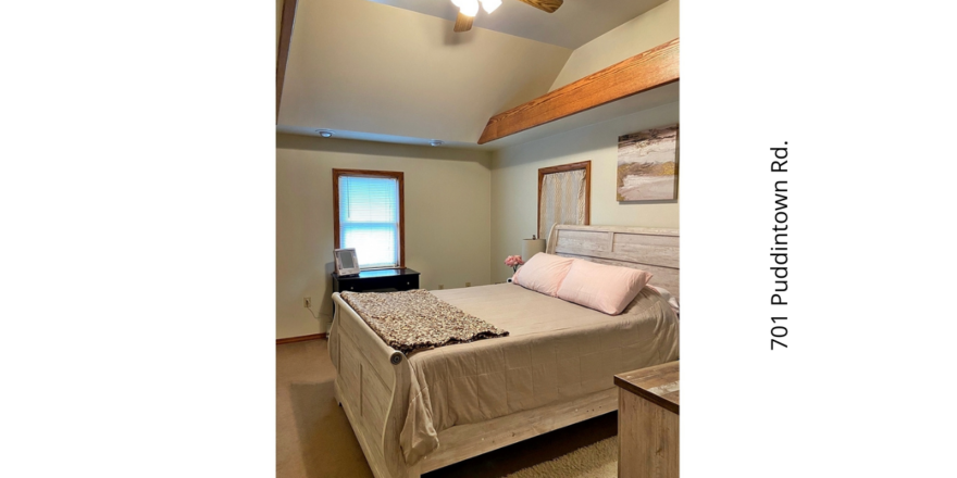 a bedroom with a ceiling fan and a bed