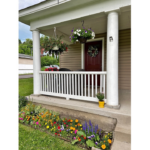 a porch with flowers and potted plants on it