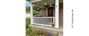 a porch with flowers and potted plants on it