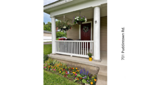 a porch with flowers and potted plants on it