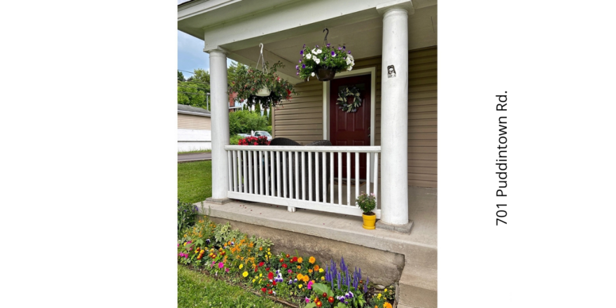a porch with flowers and potted plants on it