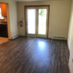 an empty living room with wood floors and sliding glass doors