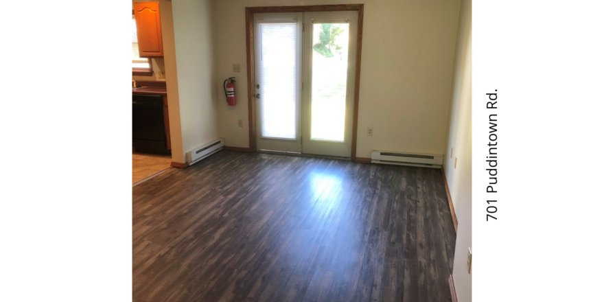 an empty living room with wood floors and sliding glass doors