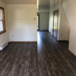 an empty living room with hard wood floors