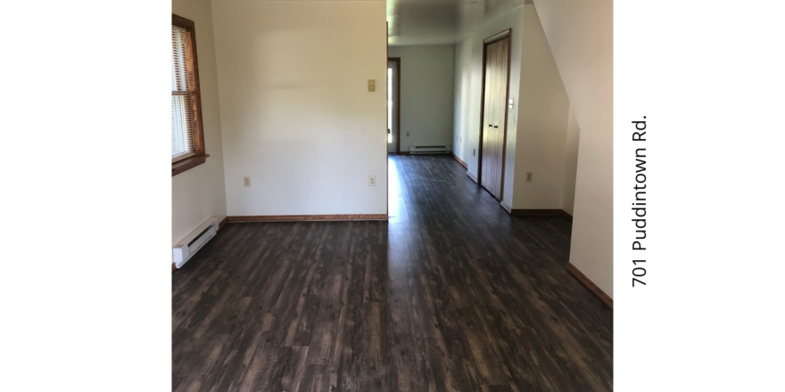 an empty living room with hard wood floors