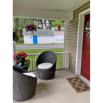 a porch with two chairs and a door