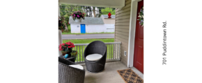 a porch with two chairs and a door