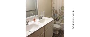 a bathroom with two sinks, a toilet and a shower curtain