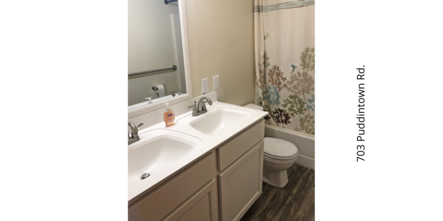 a bathroom with two sinks, a toilet and a shower curtain