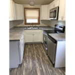 a kitchen with white cabinets and stainless steel appliances