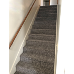a carpeted staircase leading up to a door