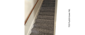 a carpeted staircase leading up to a door