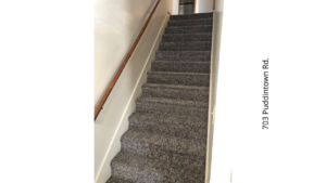 a carpeted staircase leading up to a door