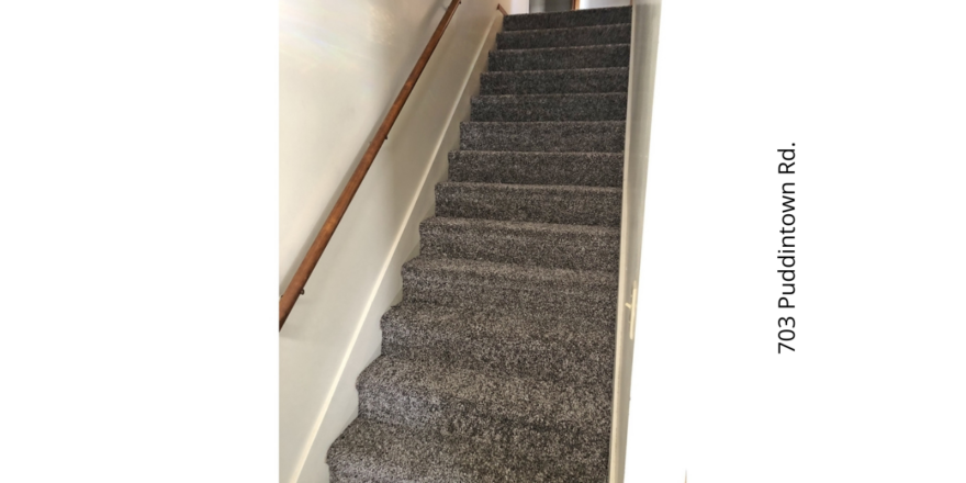 a carpeted staircase leading up to a door