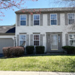 a two story house with white siding, gray shutters on windows, and a two car garage with gray doors