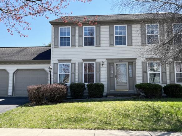 a two story house with white siding, gray shutters on windows, and a two car garage with gray doors