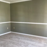 view of the den with no furniture, walls painted green and light brown carpeting