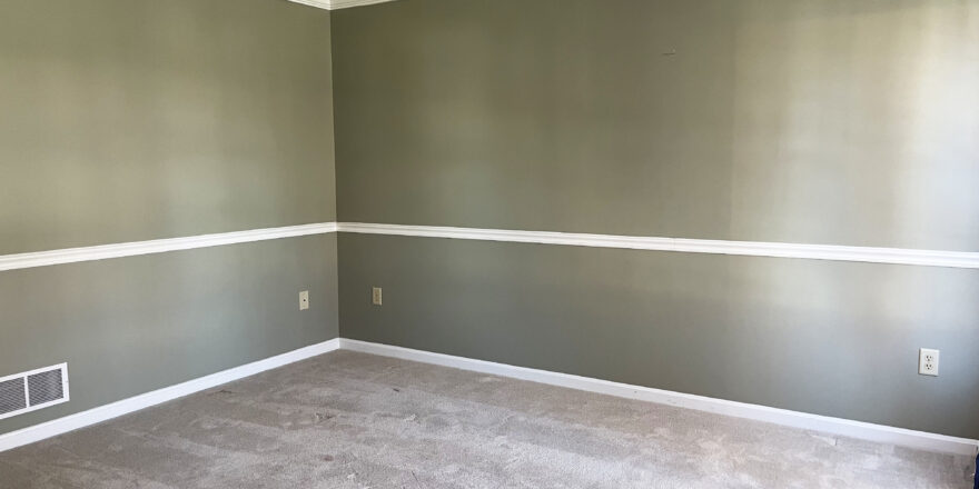 view of the den with no furniture, walls painted green and light brown carpeting