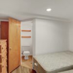 two beds in a small room with a wooden dresser
