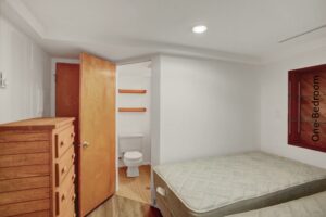 two beds in a small room with a wooden dresser