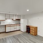 an empty kitchen with white appliances and wood cabinets
