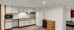 an empty kitchen with white appliances and wood cabinets