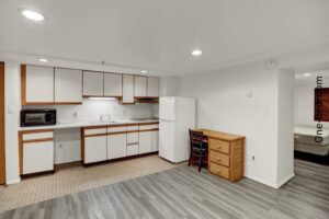an empty kitchen with white appliances and wood cabinets