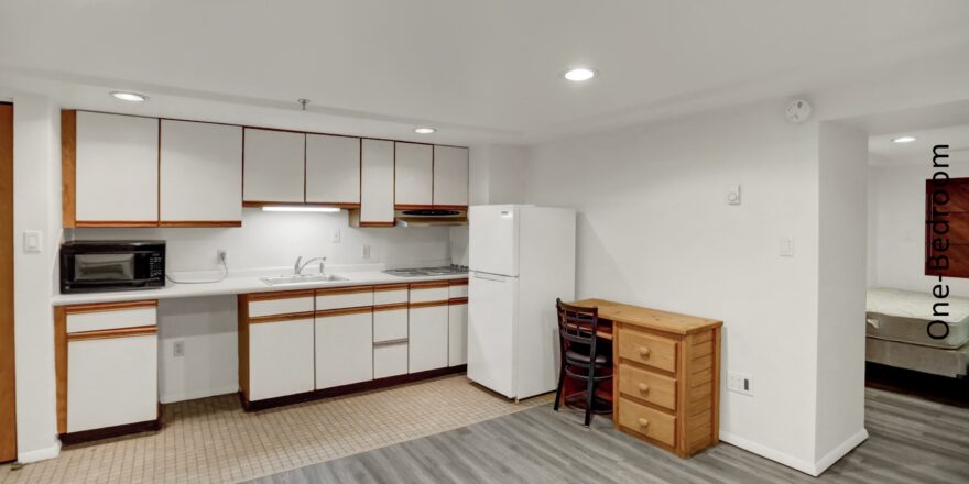 an empty kitchen with white appliances and wood cabinets