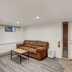a living room with a brown couch and wooden coffee table