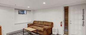 a living room with a brown couch and wooden coffee table