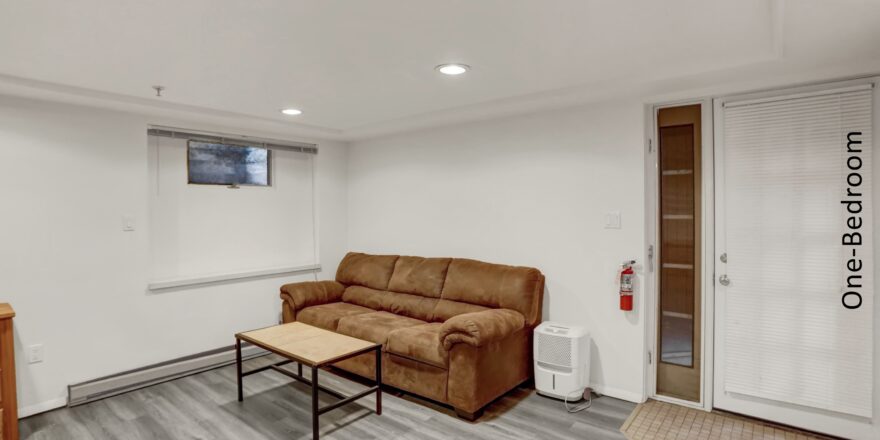 a living room with a brown couch and wooden coffee table