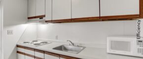 a kitchen with white cabinets and a microwave