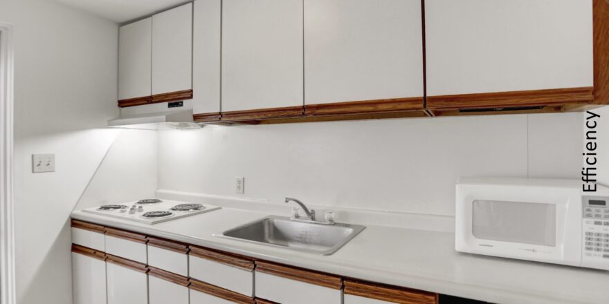 a kitchen with white cabinets and a microwave