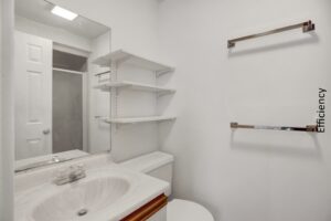 a bathroom with a toilet, sink and shelves