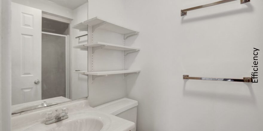 a bathroom with a toilet, sink and shelves