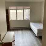 an empty bedroom with a bed and window