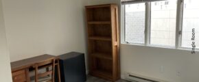 a room with a desk, bookcase and television