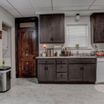 downstairs unit kitchen with counter top space and dark wooden cabinets