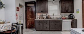 downstairs unit kitchen with counter top space and dark wooden cabinets