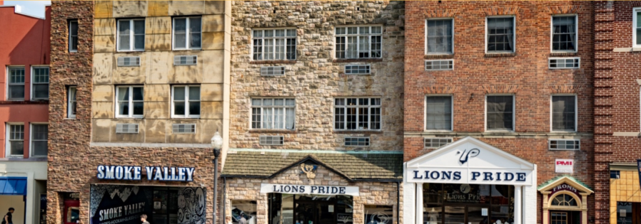 a group of cars driving down a street next to tall buildings