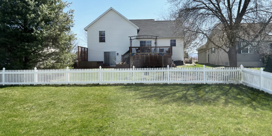 a white picket fence in backyard