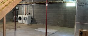 an unfinished basement with washer and dryer